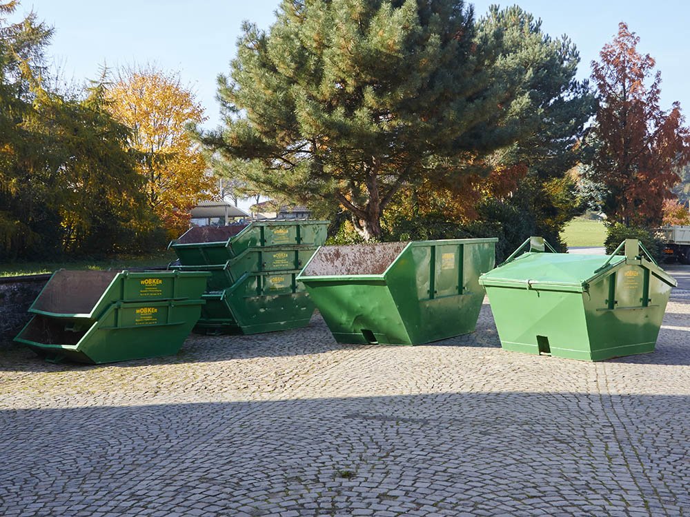 Mehrere gr&uuml;ne Mulden und Container von Wobker Baustoffe e.K. in unterschiedlichen Gr&ouml;&szlig;en auf dem Betriebshof in Melle